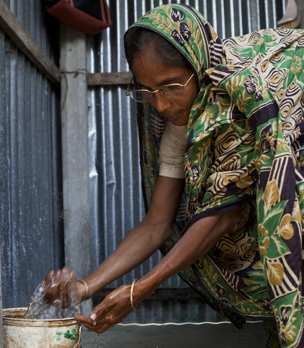 Woman washing hands at a bucket