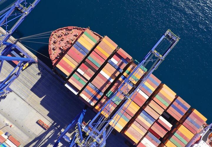 An aerial view of a ship container by a port 