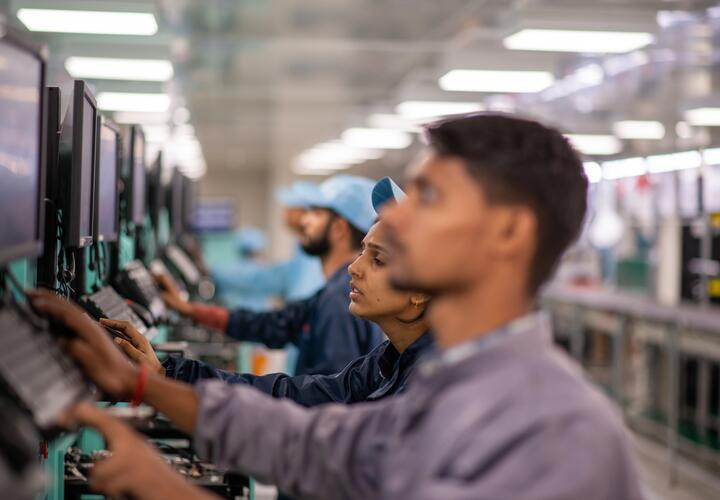 Line of male and female workers at computers standing and working. 